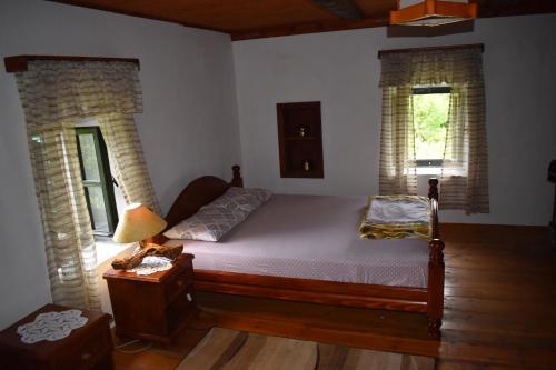 a bedroom with a bed and two windows at Old house Nilovic in Livari