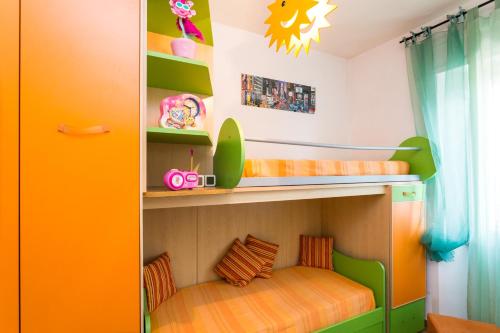 a bunk bed in a childs room with orange and green at Casa Laura Follonica in Follonica