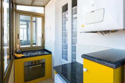 a kitchen with a yellow stove and a window at Casa Laura Follonica in Follonica