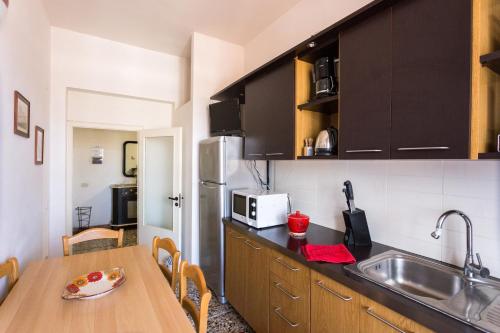 a kitchen with a wooden table and a sink at Casa Laura Follonica in Follonica