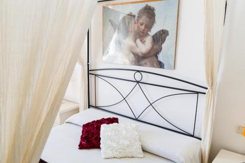 a bedroom with a bed with a picture on the wall at Casa Laura Follonica in Follonica