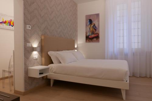 biała sypialnia z łóżkiem i oknem w obiekcie S B&B (Pescara Centro) w mieście Pescara