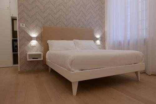 a bedroom with a white bed with two lights on it at S B&B (Pescara Centro) in Pescara