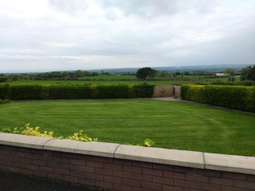 a large grassy yard with a brick wall at Antrim Heights Estate in Antrim