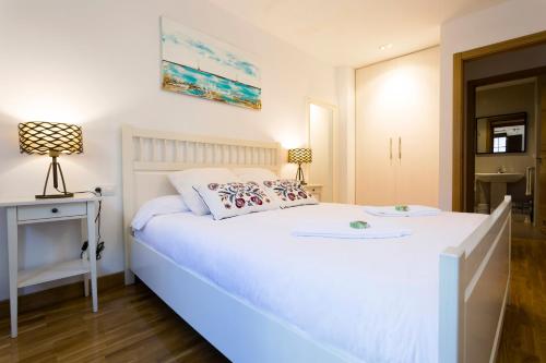 a white bedroom with a white bed and a table at Ubilla - Basquenjoy in Hondarribia