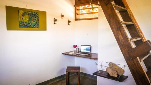a room with a ladder and a laptop on a wall at Vibra Guesthouse Popoyo in Popoyo