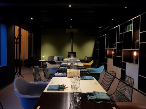 a long dining room with a long table and chairs at bosbAAr in Kluisbergen