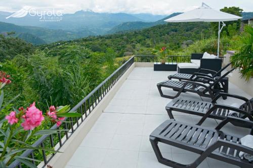 a balcony with benches and a view of the mountains at Gyrola Birding Hotel Boutique in La Mesa