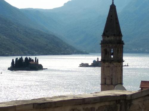 a clock tower in the middle of a body of water at Old House Perast in Perast