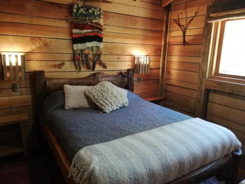 a bedroom with a bed in a log cabin at Cabañas Rústicas Pucón Río Trancura in Pucón