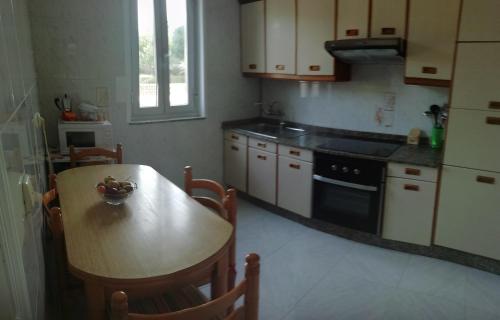 kuchnia z drewnianym stołem, stołem i kuchenką w obiekcie Casa Pozo das Leiras (Derecha) w mieście Ares