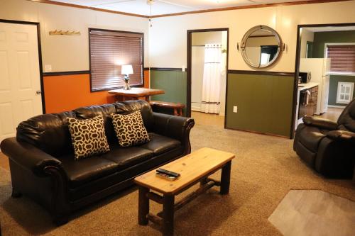 a living room with a leather couch and a coffee table at Lone Fir Resort in Cougar