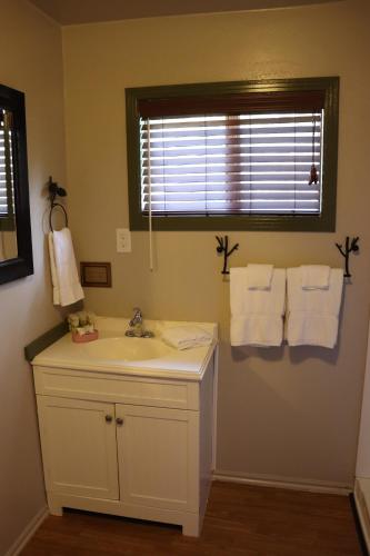 a bathroom with a sink and a window and towels at Lone Fir Resort in Cougar