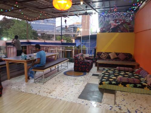 a man sitting at a table in a restaurant at Backpackers Villa Mumbai in Mumbai