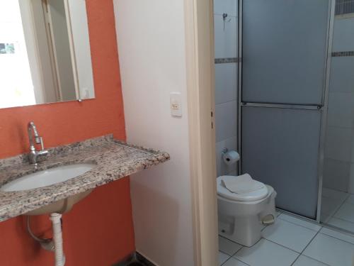 a bathroom with a sink and a toilet at Pousada Casa Doce Vida in Águas de Lindóia