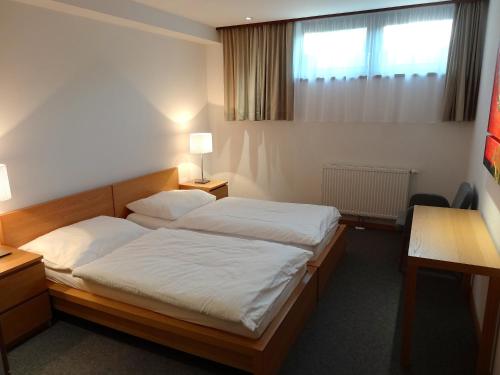a hotel room with two beds and a desk at Chalet Das Atrium in Radstadt