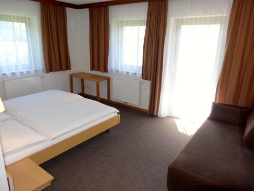a bedroom with a bed and two windows at Chalet Das Atrium in Radstadt
