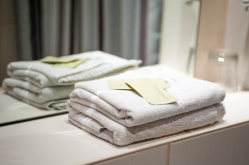 a pile of towels sitting on a counter in a bathroom at Hotel Elegia am Kurfürstendamm in Berlin