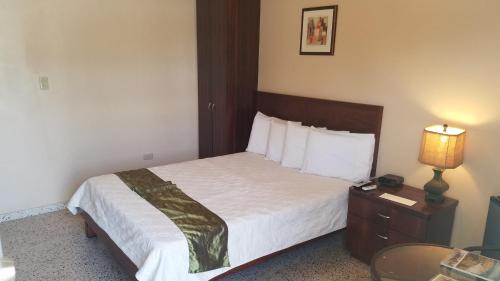 a hotel room with a bed and a table with a lamp at Combate Beach Resort in Cabo Rojo
