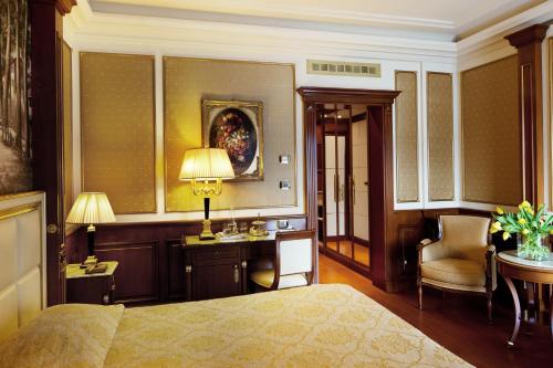 a bedroom with a bed and a desk and a chair at Hotel Splendid in Baveno