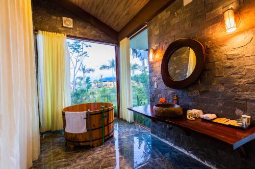 a bathroom with a barrel tub and a mirror at Hamya Hotsprings and Resort in Quang Ngai