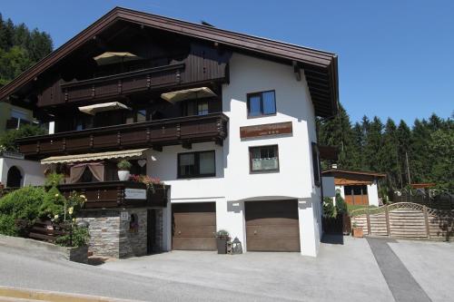 a large white house with two garage at Gästehaus Waldrand Garni in Wiesing