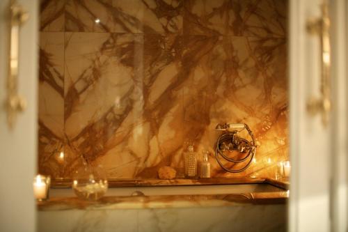 a bathroom with a marble wall with a bike on a shelf at Hotel Splendid in Baveno