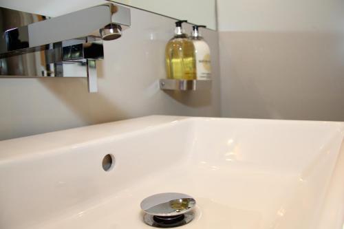 a white sink in a bathroom with a fire extinguisher at The Vineyard Lamberhurst in Lamberhurst