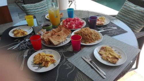 ein Tisch mit Tellern voller Frühstücksspeisen darauf in der Unterkunft Pura Villa in Sanur