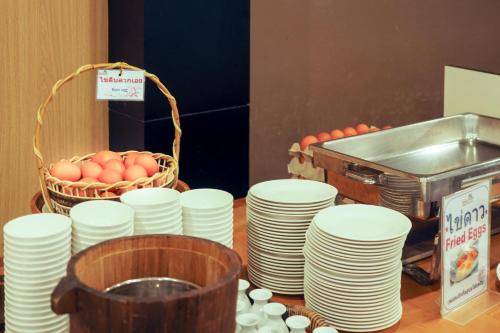 a table topped with white plates and a basket of eggs at Chaolao Cabana Resort in Chao Lao Beach