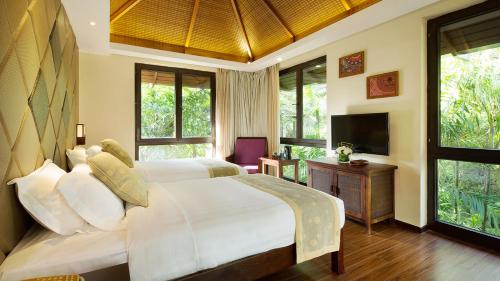 a bedroom with a bed and a tv and windows at Sanya Yalong Bay Villas & Spa in Sanya