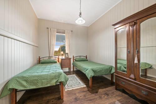 a bedroom with two beds and a mirror at Mountview Homestead near Toowoomba in Ramsay