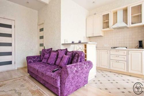 ein lila Sofa in einem Zimmer mit Küche in der Unterkunft Apartment at the railway station in Minsk