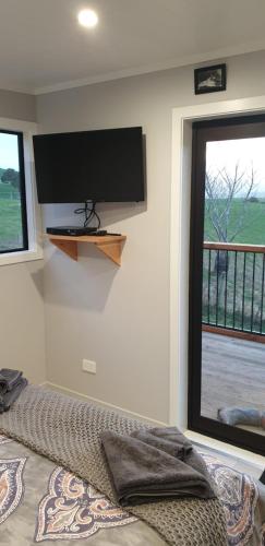 a bedroom with a flat screen tv on the wall at Lawfield in Glenomaru