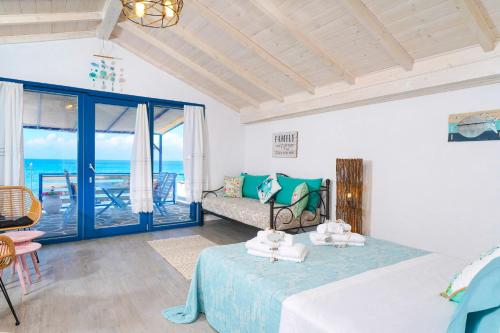 a bedroom with a bed and a view of the ocean at GLAROS BUNGALOW in Skala Kallirachis