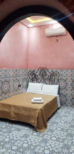a bedroom with a bed with two towels on it at Hotel Wissam in Marrakech