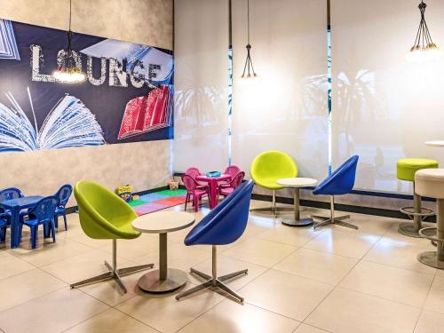 a waiting room with colorful chairs and tables at ibis budget Sorocaba in Sorocaba