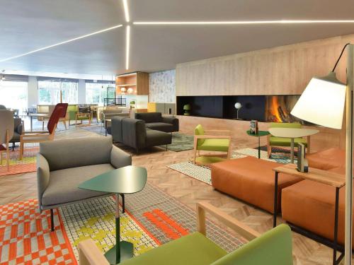 ワーヴルにあるNovotel Wavre Brussels Eastのロビー(椅子、テーブル、暖炉付)