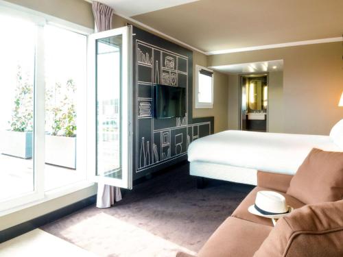 a hotel room with a bed and a large window at ibis Toulon La Valette in La Valette-du-Var