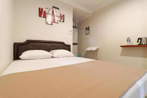 a bedroom with a bed with white sheets and pillows at Wisma Surya in Pangkalanuringin