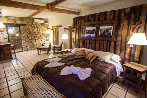 a bedroom with a large bed with towels on it at Villa Bonita Cabañas y Suites in San Rafael