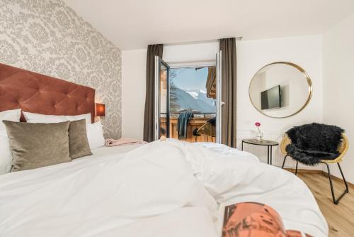 a bedroom with a bed and a mirror and a window at Emma's kleines Hotel in Ramsau im Zillertal