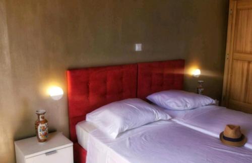 łóżko z czerwonym zagłówkiem z kapeluszem w obiekcie Accommodation Santor w mieście Lastovo