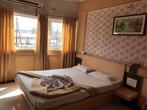 um quarto com uma cama grande e uma janela em Bharati Lodge em Hubli