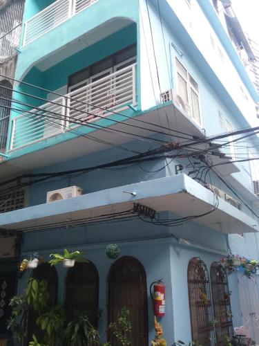 a blue and white house with a balcony at Danee Hostel in Bangkok