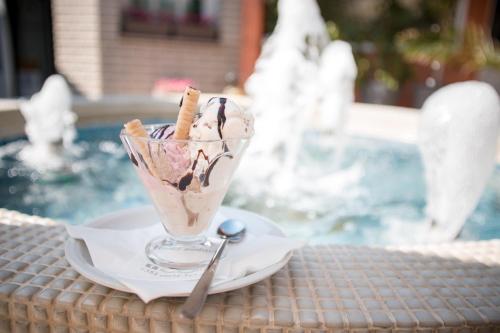 a dessert in a glass on a plate on a table at Garni Hotel Radović in Kragujevac