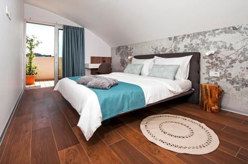 a bedroom with a large bed and wooden floors at The Q Superior - a penthouse with jacuzzi and sauna in Rovinj