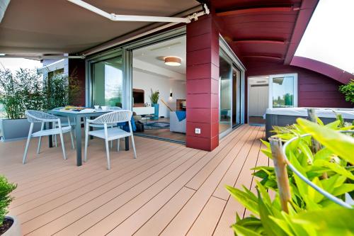 a patio with a table and chairs on a deck at The Q Superior - a penthouse with jacuzzi and sauna in Rovinj