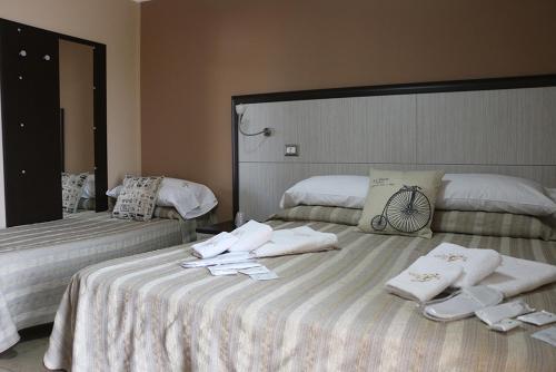 2 Betten in einem Zimmer mit Handtüchern darauf in der Unterkunft B&B Gattopardo in Cariati