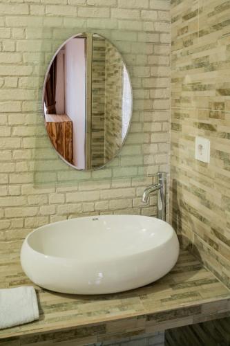 a bathroom with a white sink and a mirror at Kayu Kuning Cottage in Nusa Penida